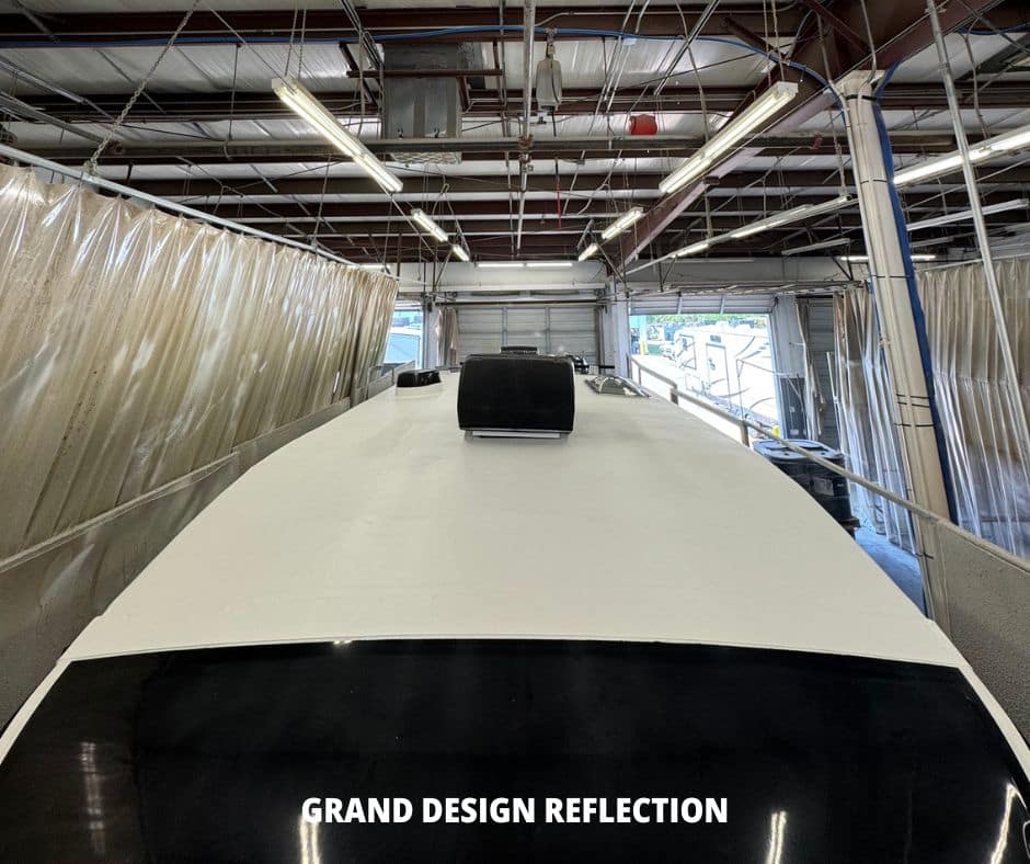 clean white rv roof with black accessories like air conditioner, vents and antenna