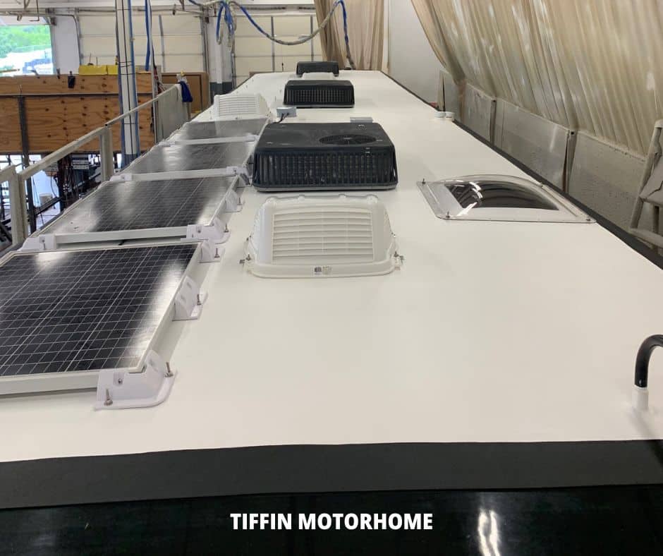 rv roof with solar panels, air conditioner, vents, and skylight